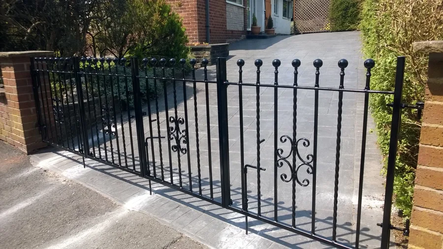 Wrought iron driveway gates with ball finials and decorative scrollwork